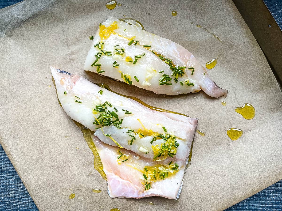 haddock fillets with lemon olive oil and chive dressing ready for the oven