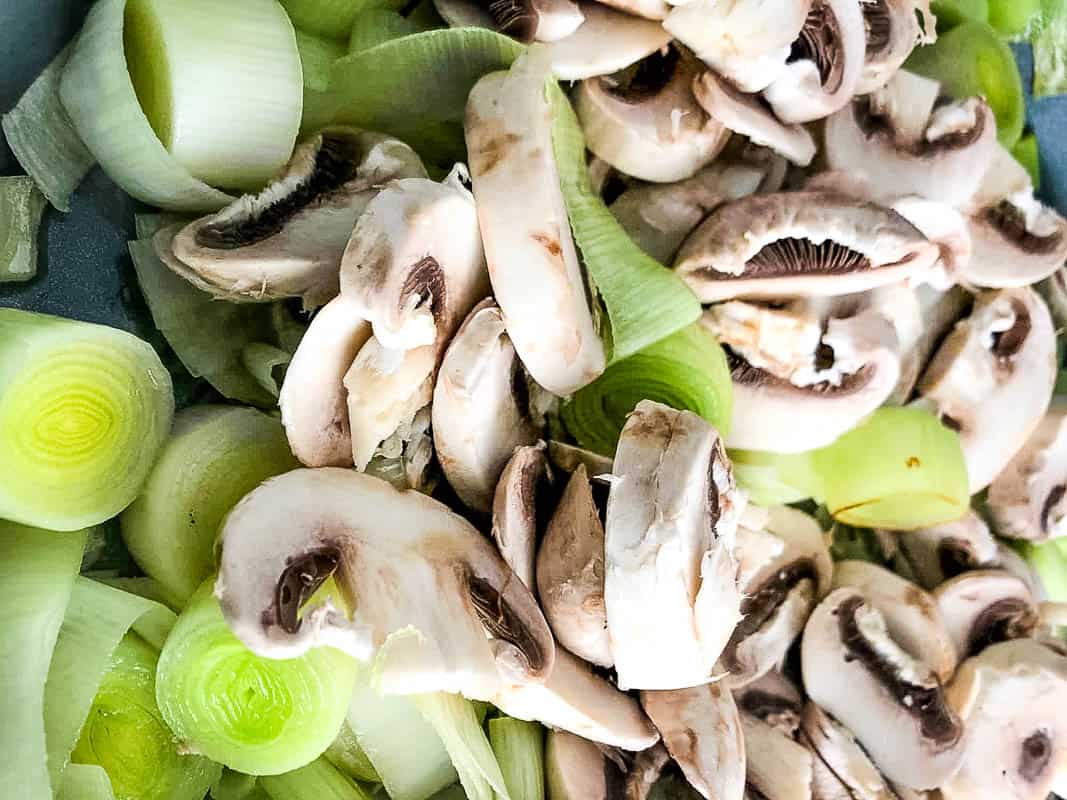 leek and mushrooms frying in pan.