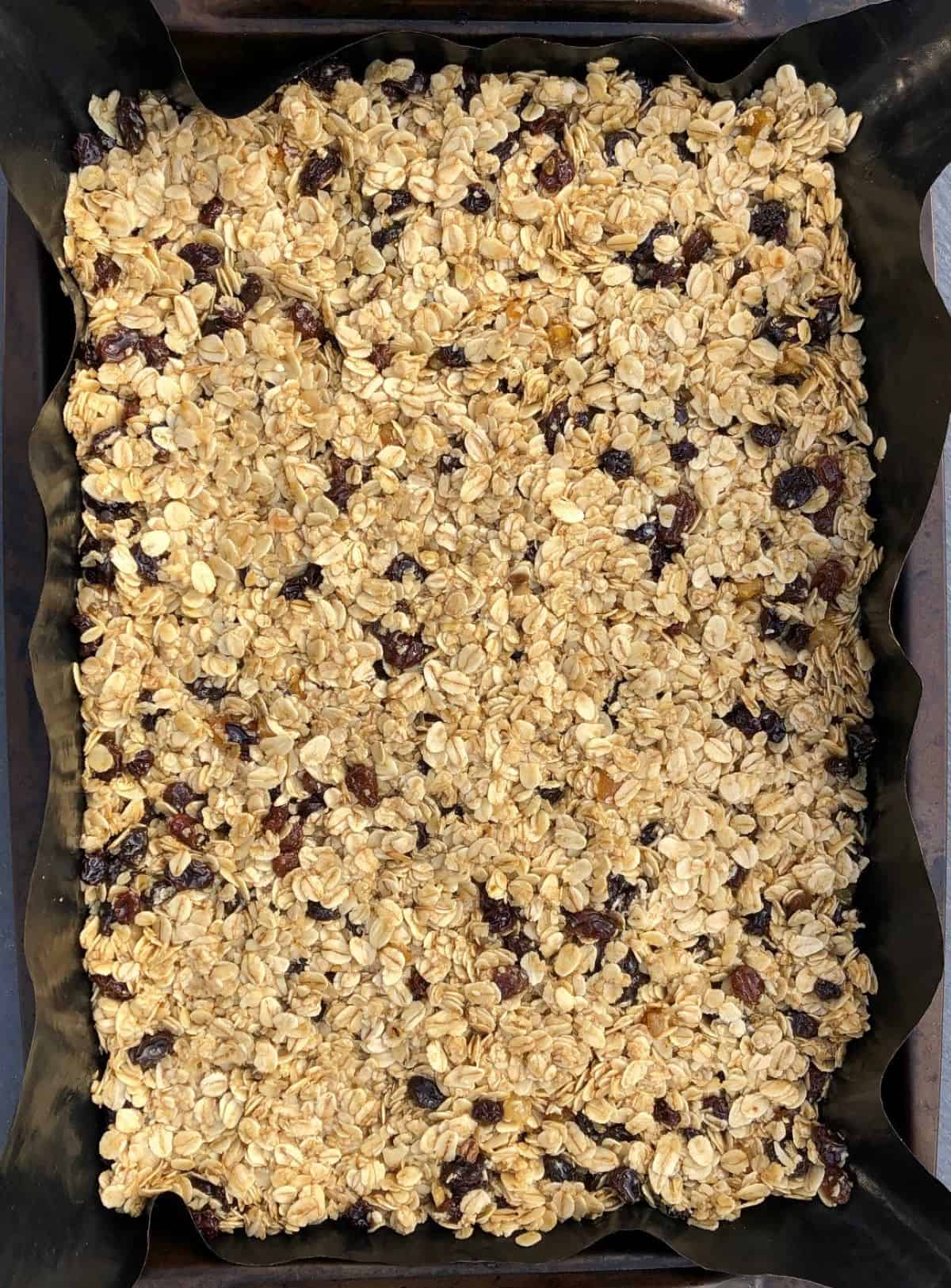 mixed dried fruit flapjack ingredients in baking tray ready for the oven.