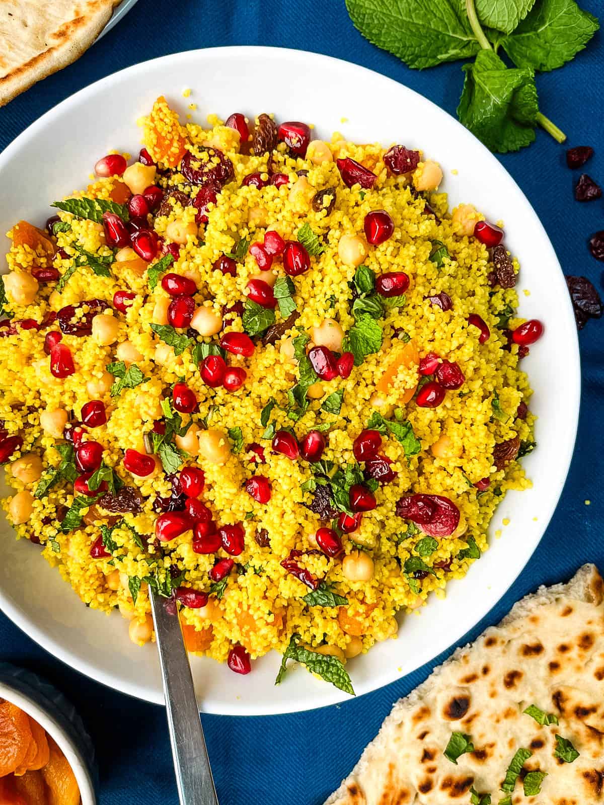 couscous with spices topped with pomegranate seeds.