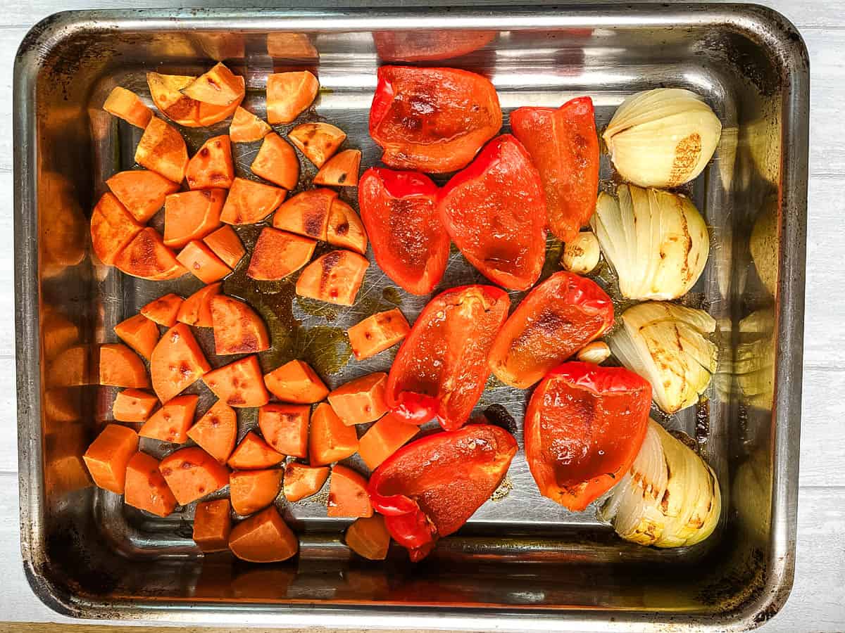 diced sweet potato red peppers garlic and onion roasted in tray.