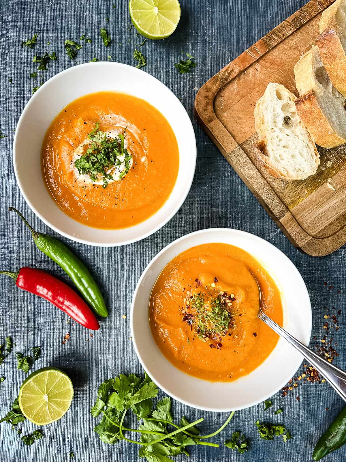 sweet potato soup with chilli in two bowls with toppings