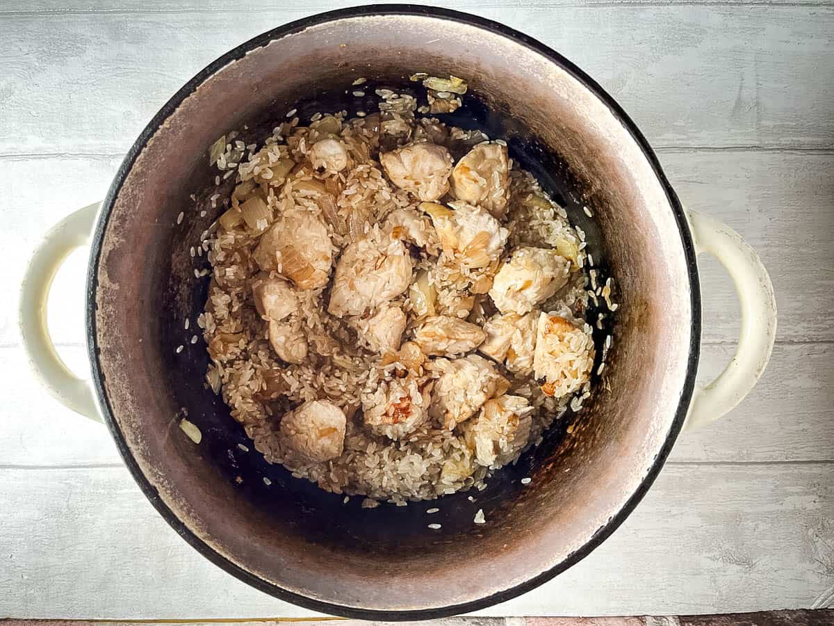 risotto rice with diced chicken and onion in pan