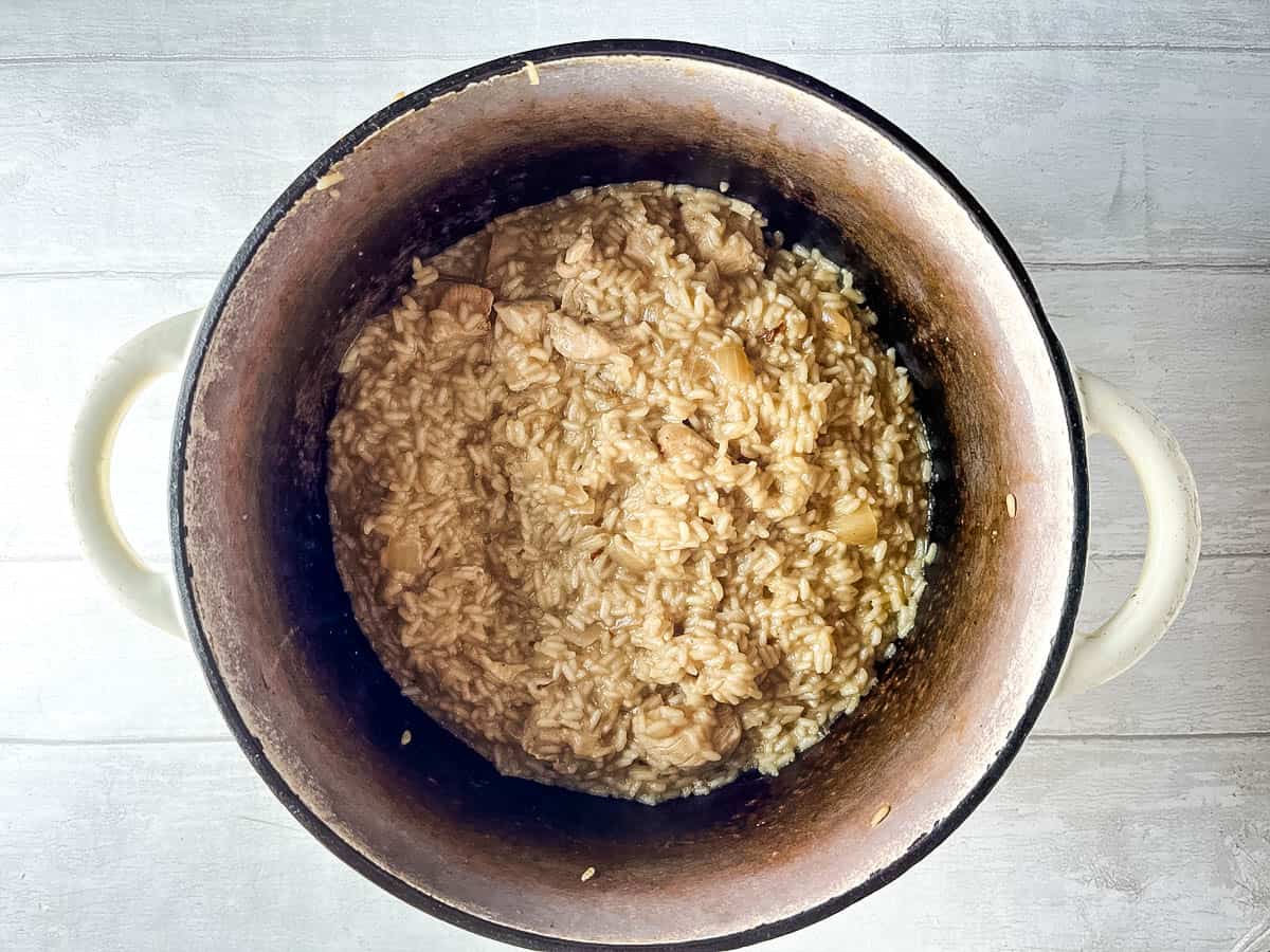 chicken risotto simmering in pan.