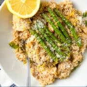 bowl of chicken risotto with asparagus and lemon.