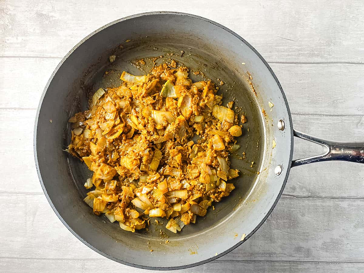 fried onion and curry paste in frying pan.
