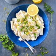 smoked haddock pasta in a bowl topped with lemon zest, fresh parsley and served with lemon half.