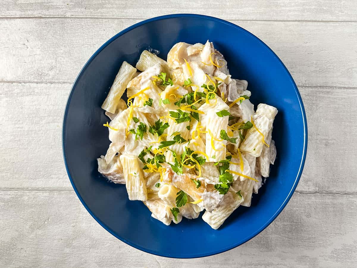 smoked haddock pasta in a bowl topped with lemon zest and fresh parsley.