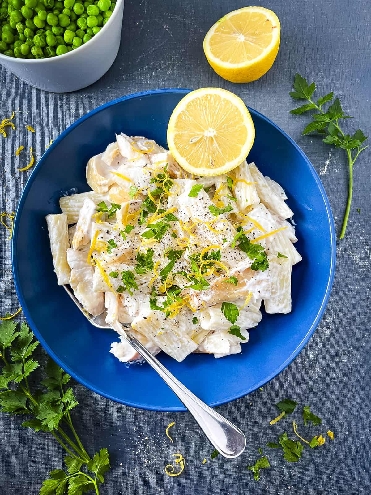 smoked haddock and pasta in a bowl topped with lemon zest and fresh parsely.