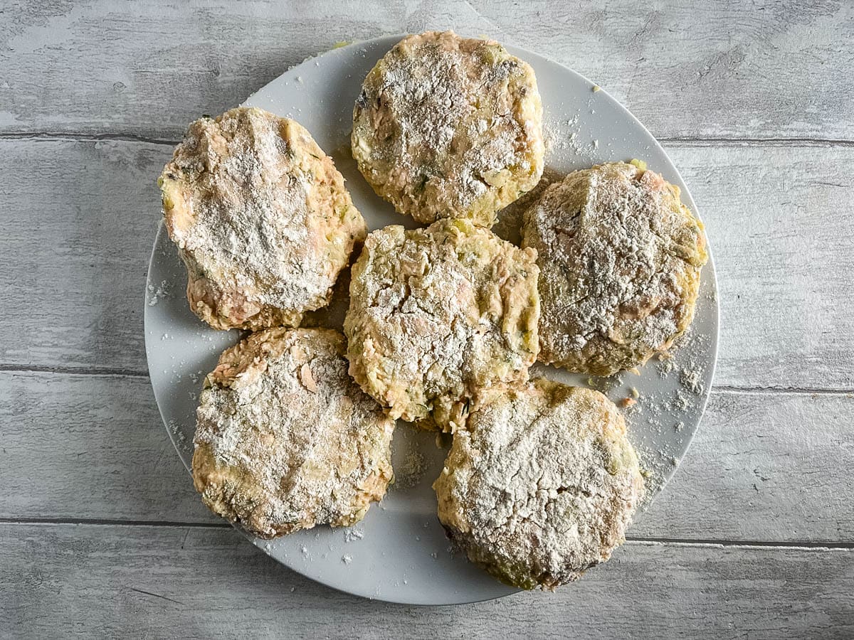 salmon fishcake mixture made into patties and laid on a plate.