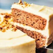 slice of banana walnut cake lifted up from whole cake to show filling