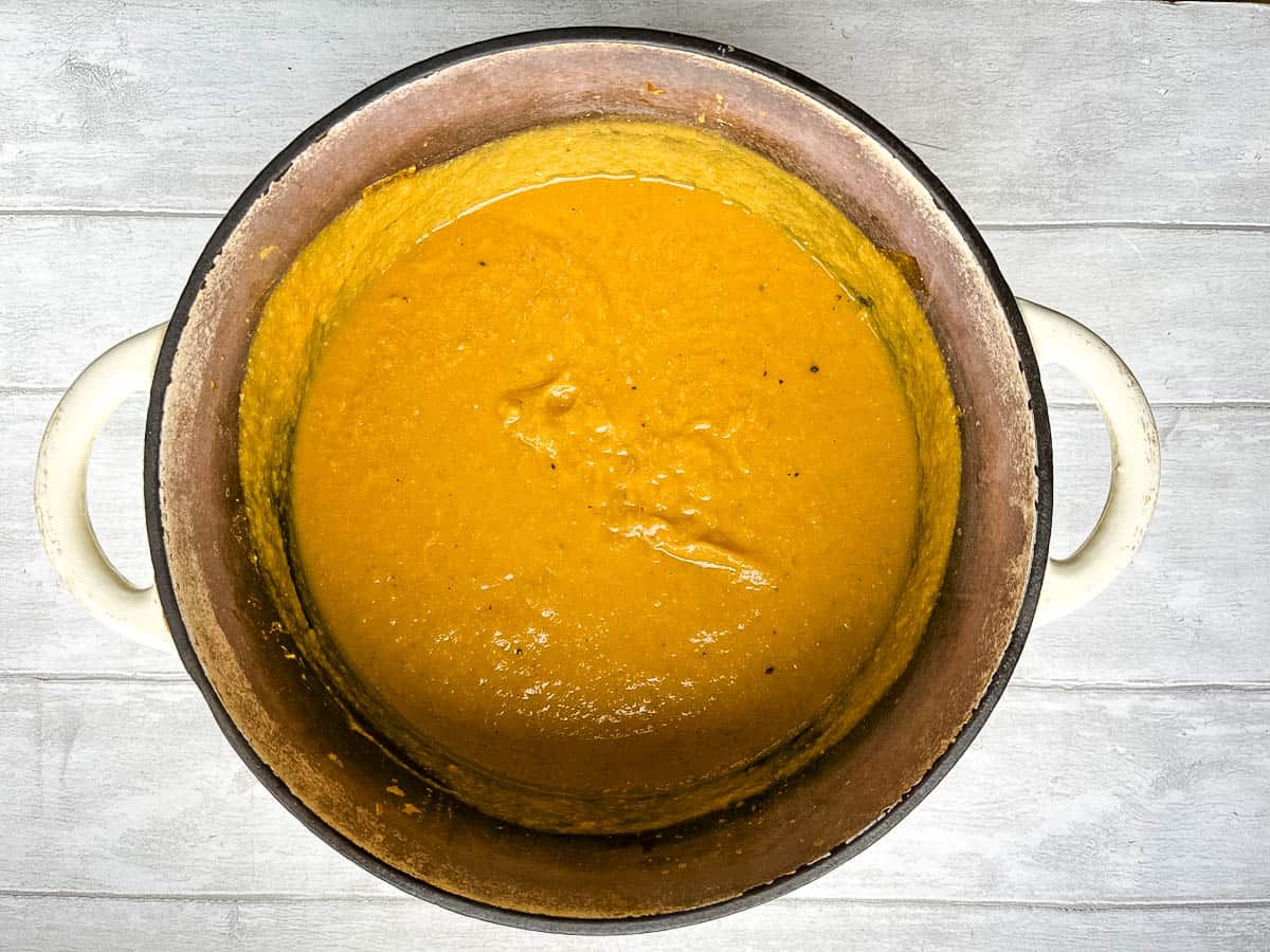 blended leek red lentil and carrot soup in pan.