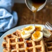 banana waffles topped with sliced banana and caramel sauce