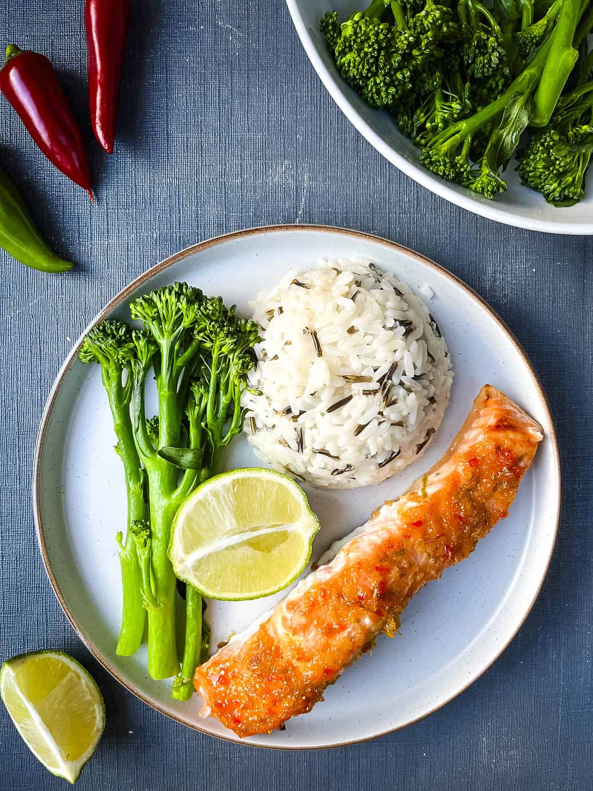 plate with baked salmon fillet, wild rice and tender stem broccoli.