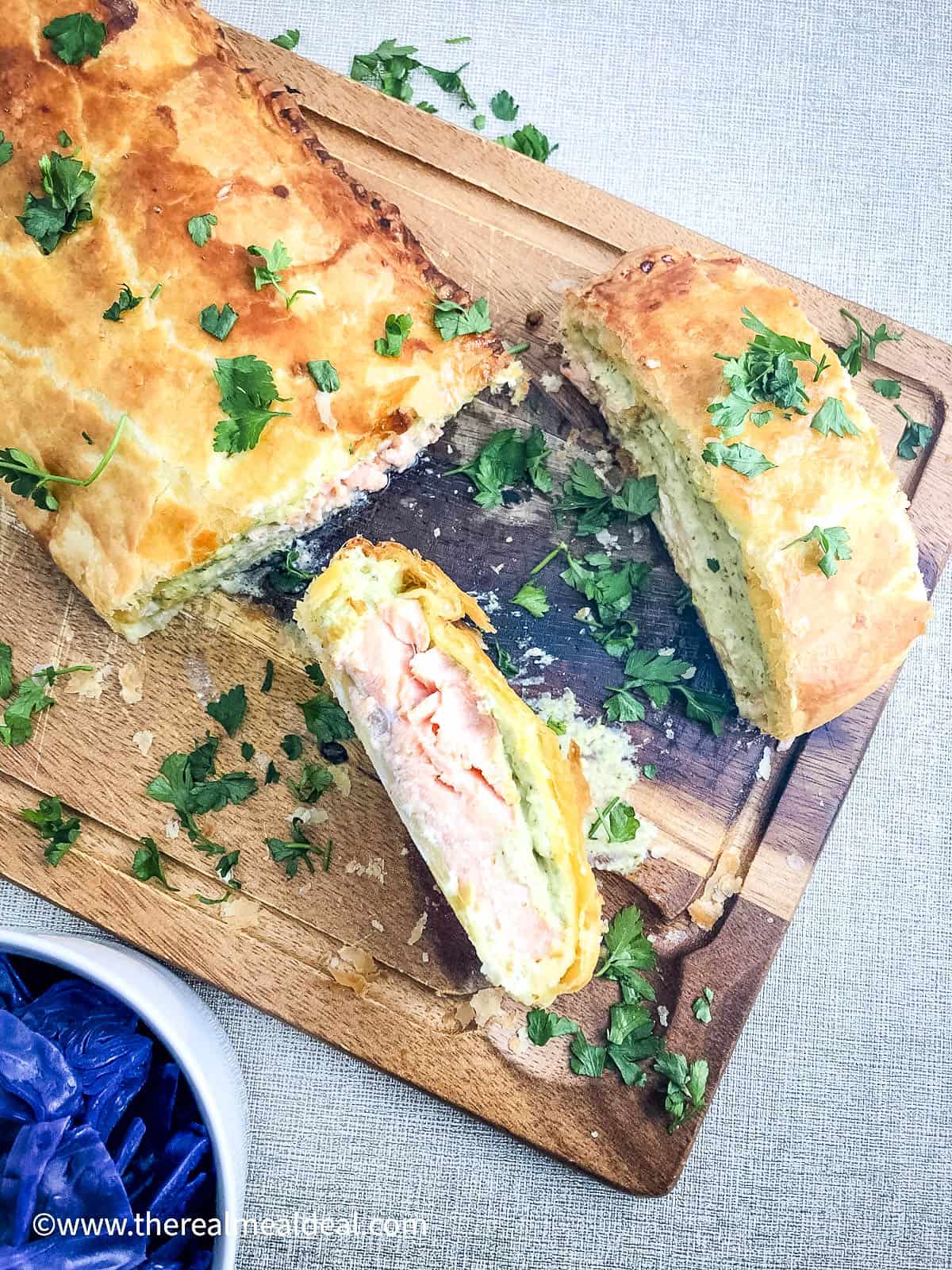 sliced salmon en croute on wooden board
