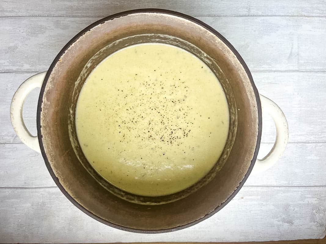 blended celery and stilton soup seasoned with salt and pepper in pan.