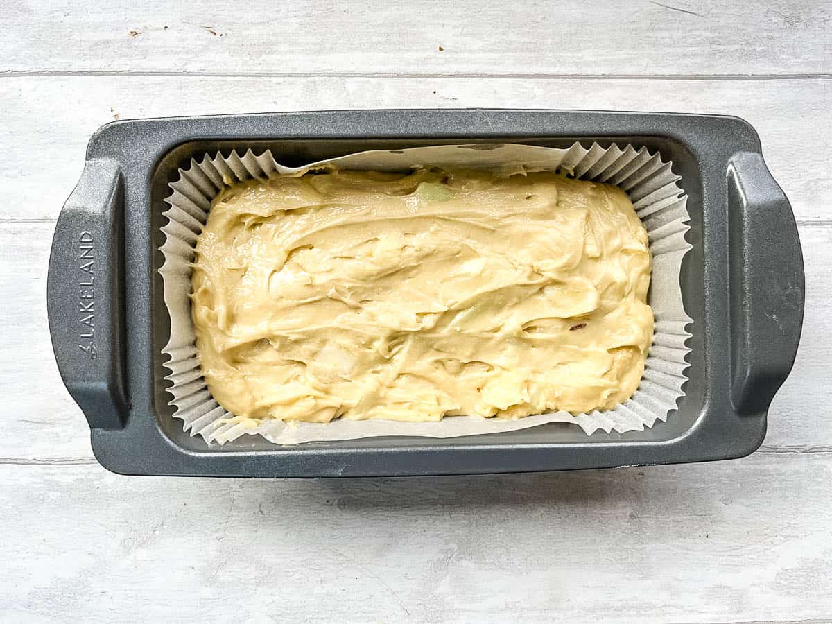 apple and pear cake batter in loaf tin ready to be cooked.