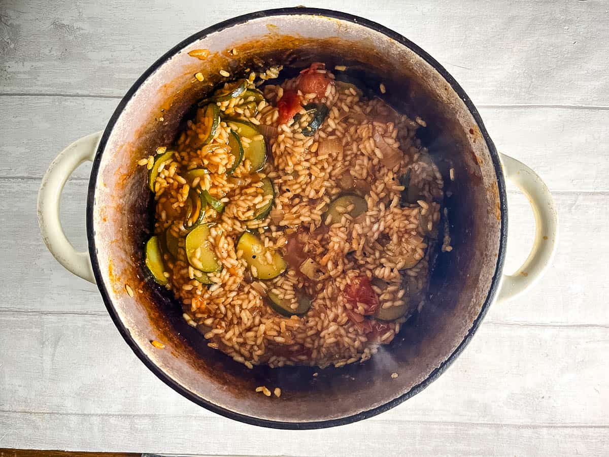tomato and courgette risotto simmered in pan.