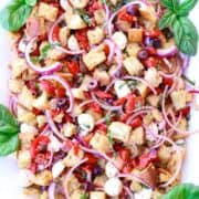 plate of panzanella salad with stale bread, red onions, cheese, tomatoes, olives