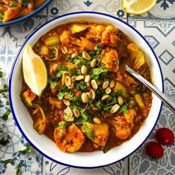 cauliflower curry topped with peanuts and coriander leaves.
