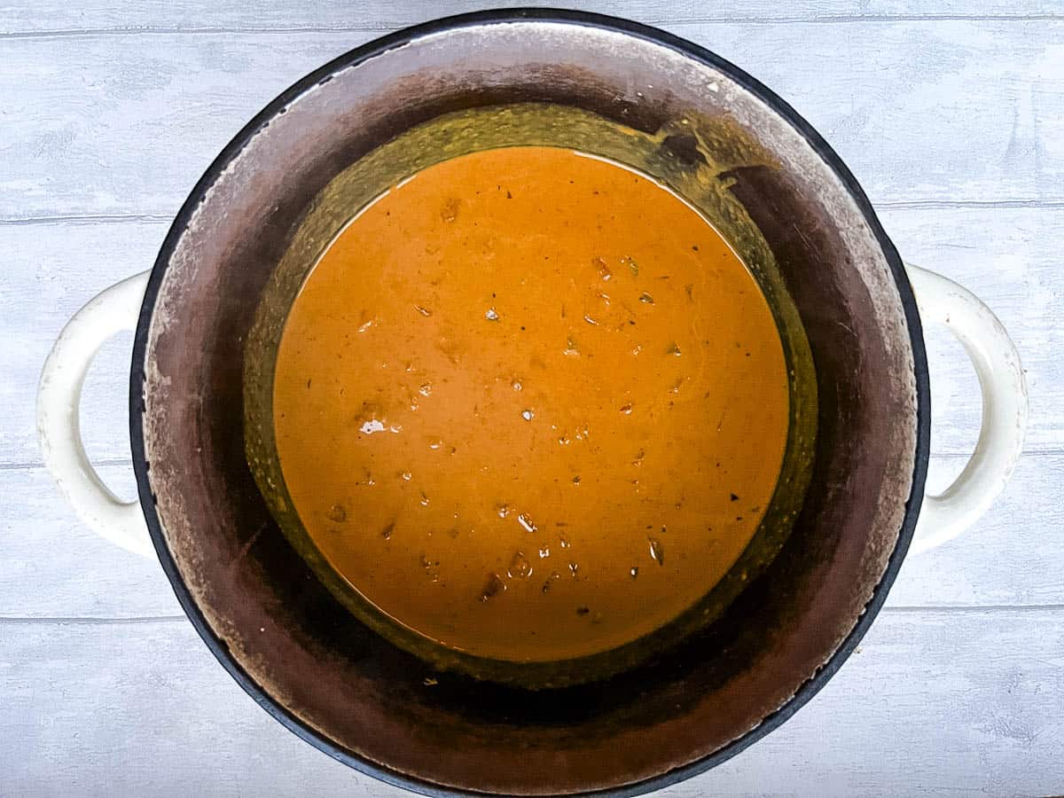 tomatoes and coconut milk added to onion in pan.