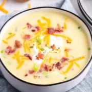 bowl of baked potato soup topped with grated cheese