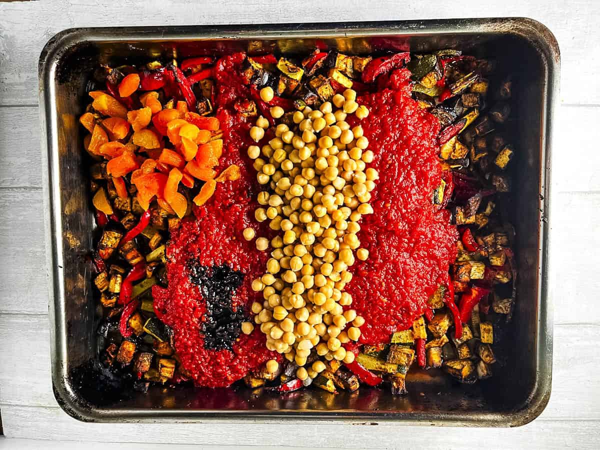 dried apricots, tinned tomatoes, balsamic vinegar, chickpeas added to roasted vegetables in tray.