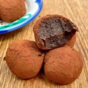 3 date truffles with a bite taken out on a table