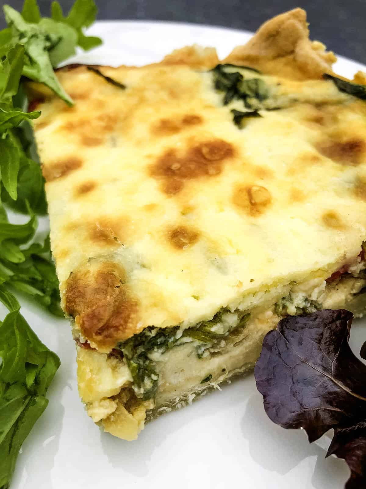 slice of quiche with spinach filling