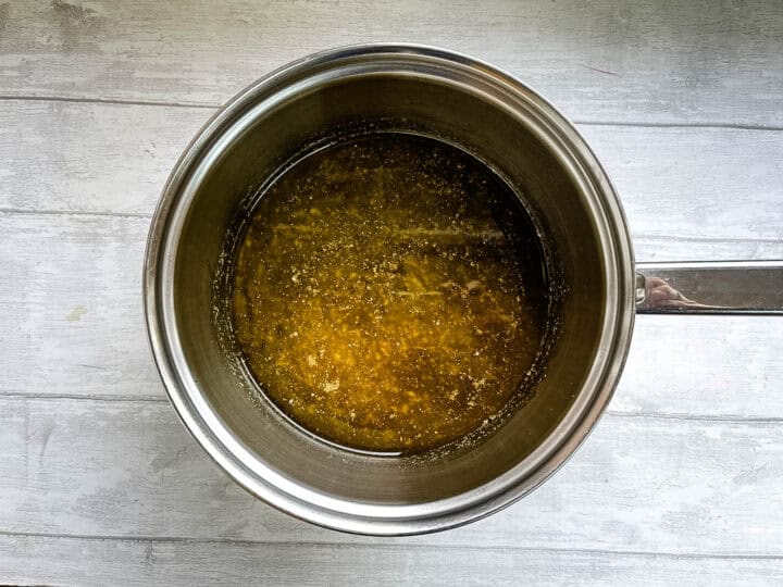 butter sugar and syrup melted in pan for fruit flapjacks.