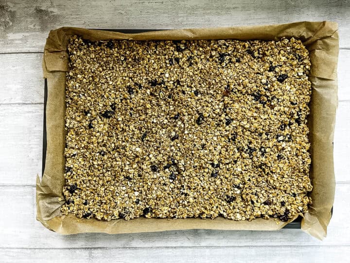 fruit flapjack mixture pressed into tin ready for baking