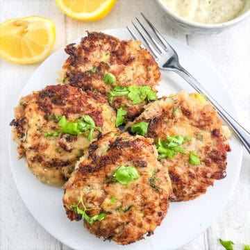 tuna fishcakes without breadcrumbs on a plate with lemon and tartare sauce