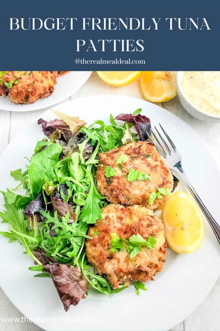 tuna patties without breadcrumbs on plate with green salad and lemon wedges.
