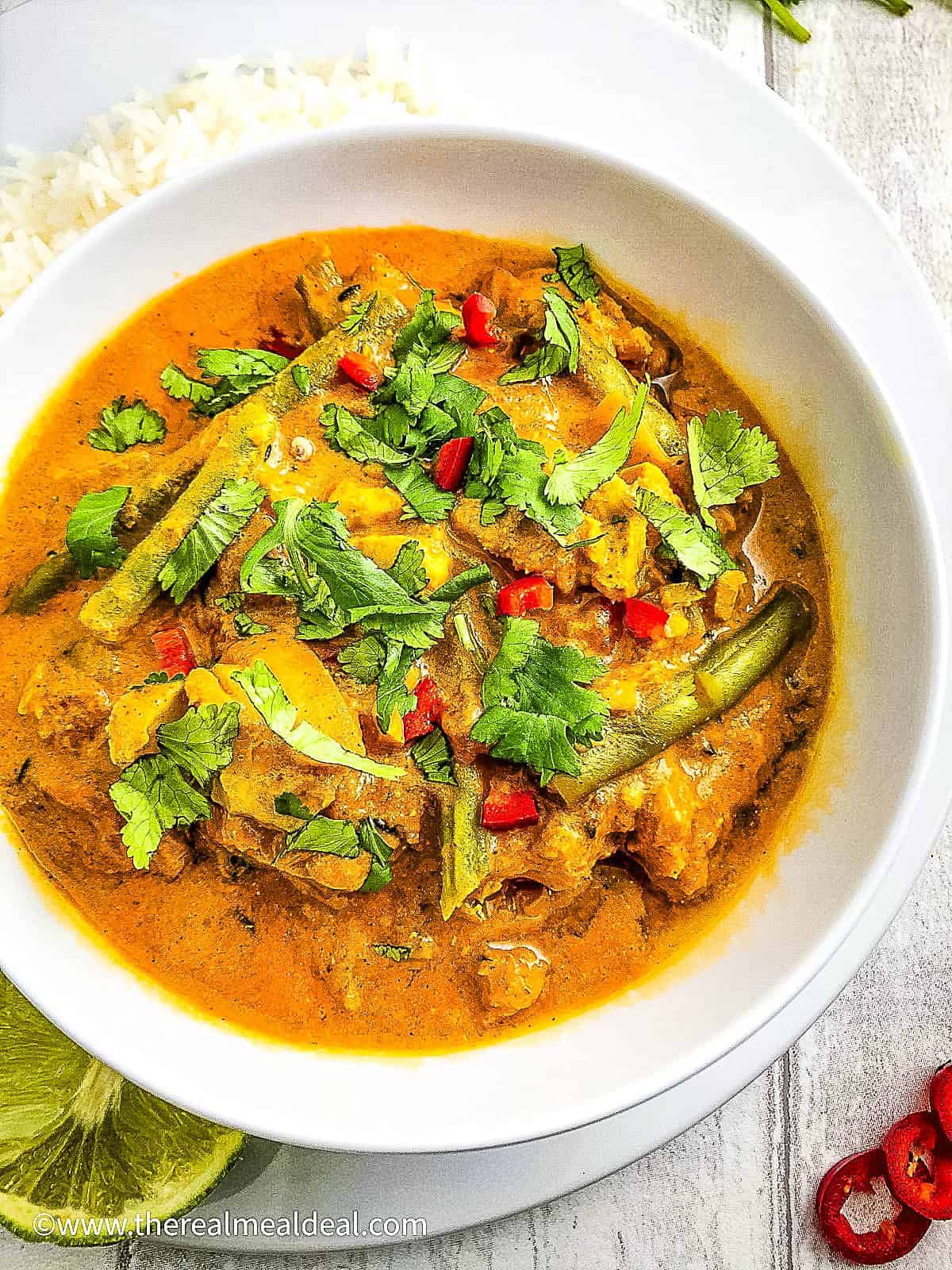 creamy keralan fish curry with coconut milk in a bowl topped with coriander leaves