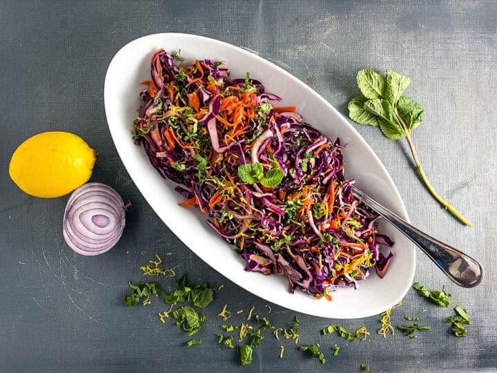 red cabbage salad with carrot and mint dressed and topped with lemon zest, resting.