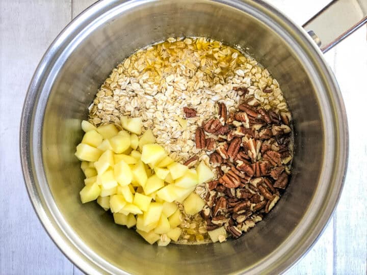 apple, oats and pecan nuts in a pan.