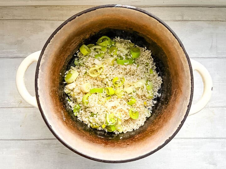 diced leeks and risotto rice in pan.
