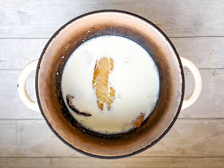 smoked haddock poaching in milk in pan.